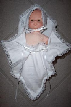 Baby dressed in bereavement pouch with bonnet